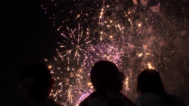 TOKYO, JAPAN - MAY 2026 : View of fireworks and back shot of people. Japanese summer season and festival concept video.