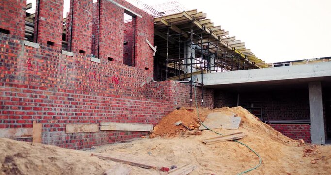Construction, infrastructure and empty building at site, brick wall and concrete for engineering. Architecture, scaffolding and exterior with incomplete development, soil and framework design