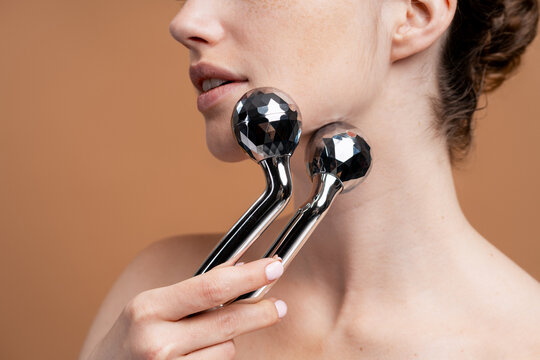 Woman using facial roller for skin firming treatment