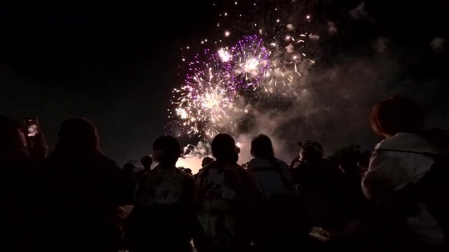TOKYO, JAPAN - MAY 2026 : View of fireworks and back shot of people. Japanese summer season and festival concept video.