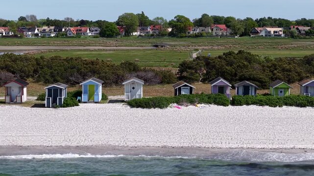 Drone shot of Skanor beach with colorful wooden huts at Baltic Sea in Sweden