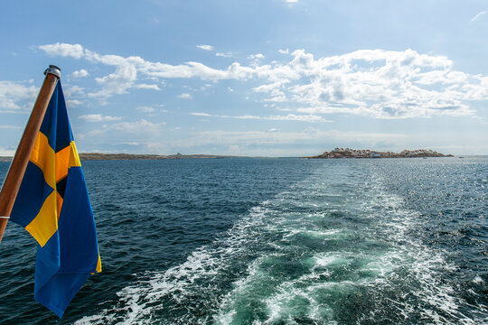 Schwedische Fahne mit Blick auf die Insel &Aring;stol in Bohusl&auml;n.