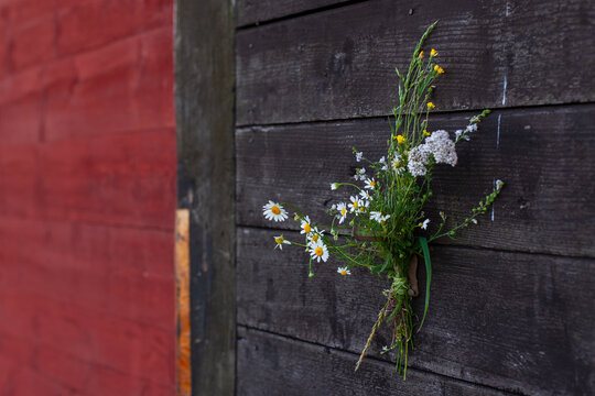 Gepfl&uuml;ckte Wiesenblumen gebunden vor roter und schwarzer Holzwand