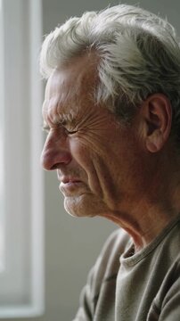 Mature man closing eyes in profile view, indoor setting, close up shot