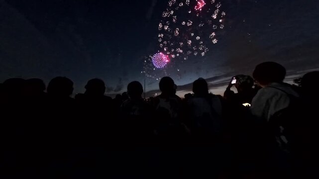 TOKYO, JAPAN - MAY 2026 : View of fireworks and back shot of people. Japanese summer season and festival concept video.