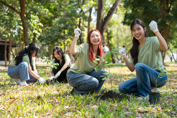 Fototapeta premium Green Thumbs and Hopeful Hearts: A group of volunteers plant a tree, embodying environmental care and communal action, with the earth under the sun.