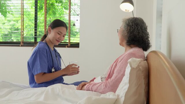 Caring Touch: A dedicated caregiver in scrubs gently interacts with an elderly patient, seated by a window, fostering trust, and emphasizing the importance of healthcare.
