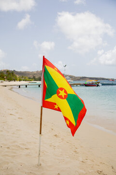 Grenada flag waving on Caribbean beach
