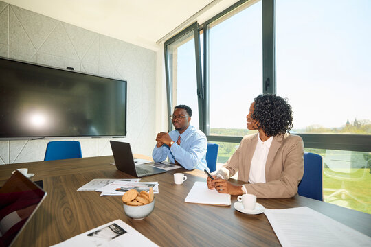 Man and woman engaged in focused discussions in a meeting