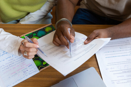 Students hands writing notes studying in library