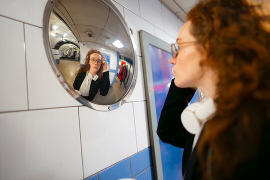 Checking reflection in subway mirror