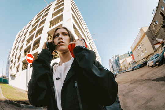 Person Talking on Two Phones in a City Street Near a Building