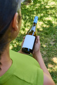 Woman holding a blank label wine bottle