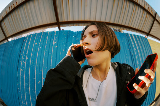 Young Person Talking on the Phone Outdoors in an Urban Setting