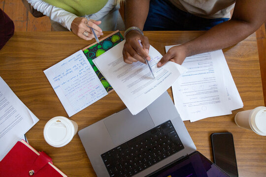 Students studying together on desk with laptop