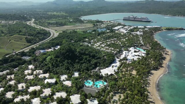Drone aerial panorama of Maimon Bay near Puerto Plata featuring Caribbean coastline, cruise tourism infrastructure, tropical forests and scenic mountain backdrop.
