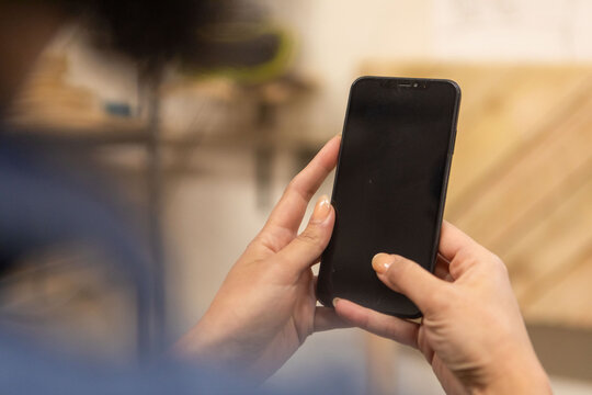 Person holding a smartphone with both hands, screen facing viewer.