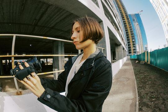 Person Holds Camera While Standing at Construction Site in Daylight