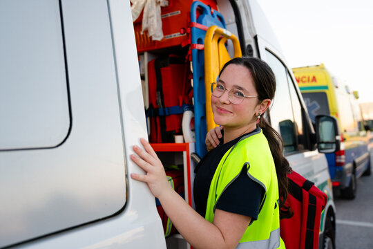 Paramedic near ambulance preparing for emergency response