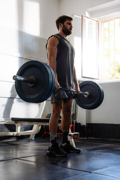 Man Performing Deadlift With Barbell In Gym