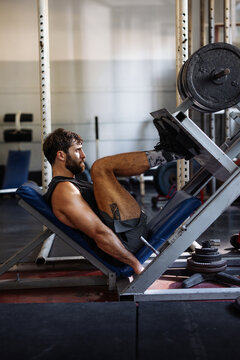 Man Doing Leg Press Workout At Gym For Fitness