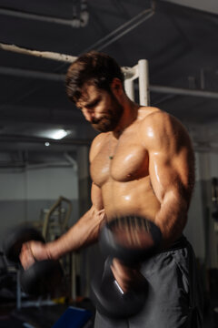 Muscular Man Lifting Dumbbells During Intense Gym Workout