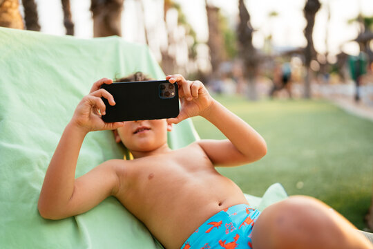 Young boy capturing video outdoors during summer vacation