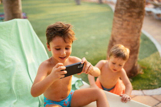 Young boy enjoying screen time with smartphone outdoors
