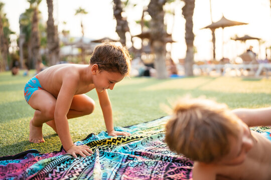 Children playing on beach towel at resort