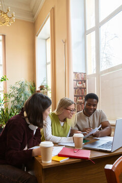 Diverse students collaborating on project in university library