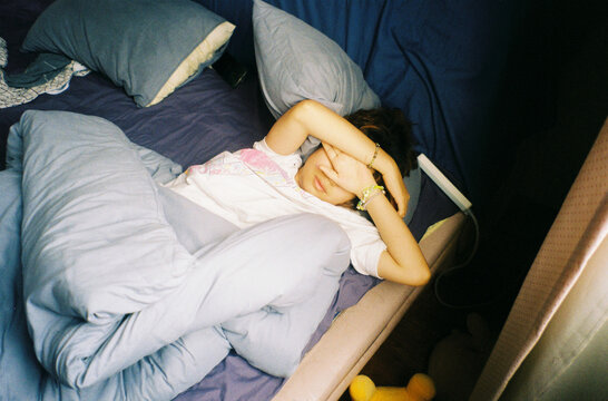 Young Woman Waking up in bed with soft natural light