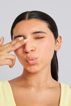 Young woman covering one eye with her fingers