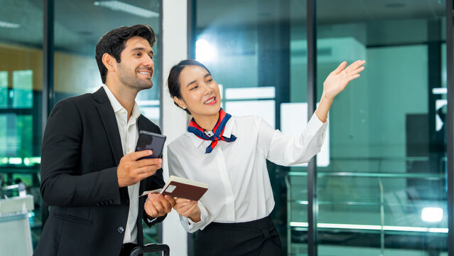Friendly airline service agent helping corporate male passenger with digital boarding pass and mobile application representing smart travel technology