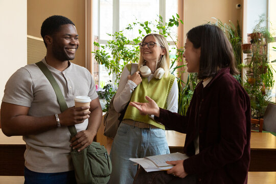 Happy students talking in university library