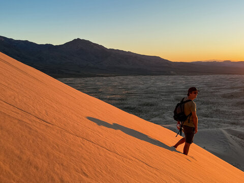 Man Admiring Sunset on Sand Dune