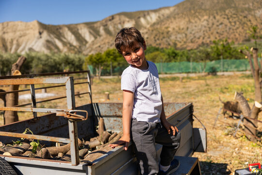 Rural child smiling standing on farm trailer