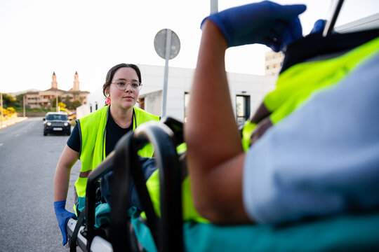 Paramedic pushing stretcher with patient