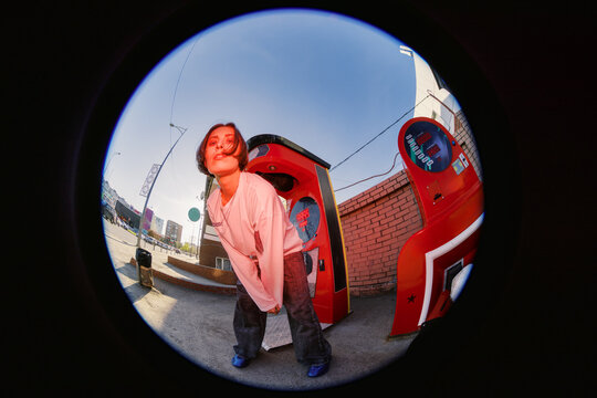 Young Person Stands Near a Large Punching Bag on a City Street