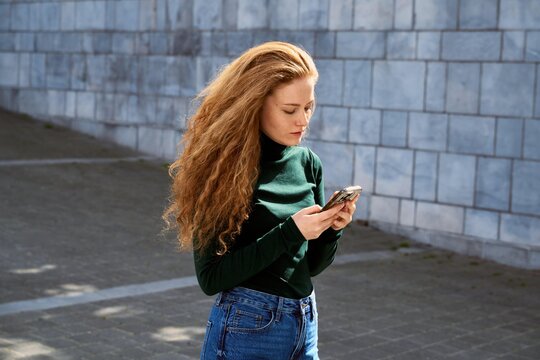 Young Woman Using Smartphone in Urban Setting During Day