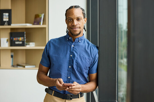 Businessman Standing by Window in Office Space