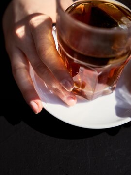 Tea Served on a White Plate in a Cafe Setting With Hands