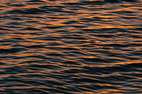 Sunlight on ocean water surface at sunset