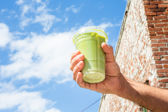 Male Hand Holding Green Matcha Drink