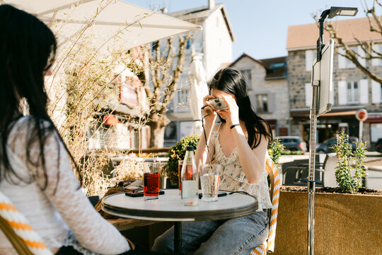 two friends, outdoors taking photos with disposable film camera 
