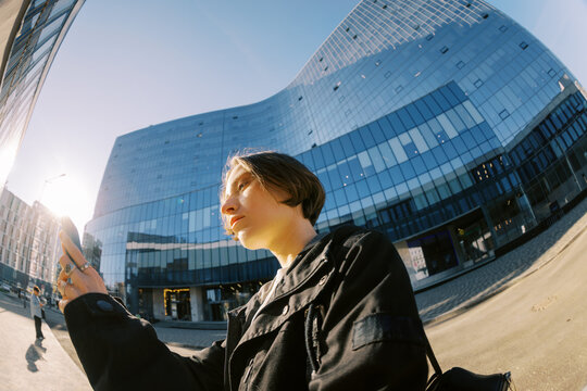 Young Woman Using Phone in Urban Area on Sunny Day