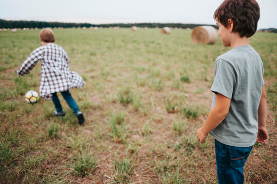 Boys Enjoy a Playful Game of Soccer in an Open Field