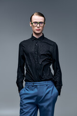 Fototapeta premium Young man showcases modern fashion with confidence in stylish studio portrait