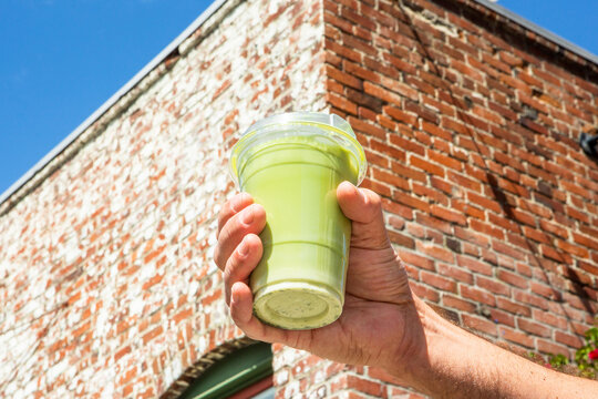 Male Hand Holding Green Matcha Drink