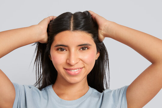 Young woman smiling while touching her hair