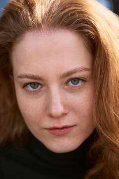 Woman With Red Hair Looking Directly at the Camera Outdoors